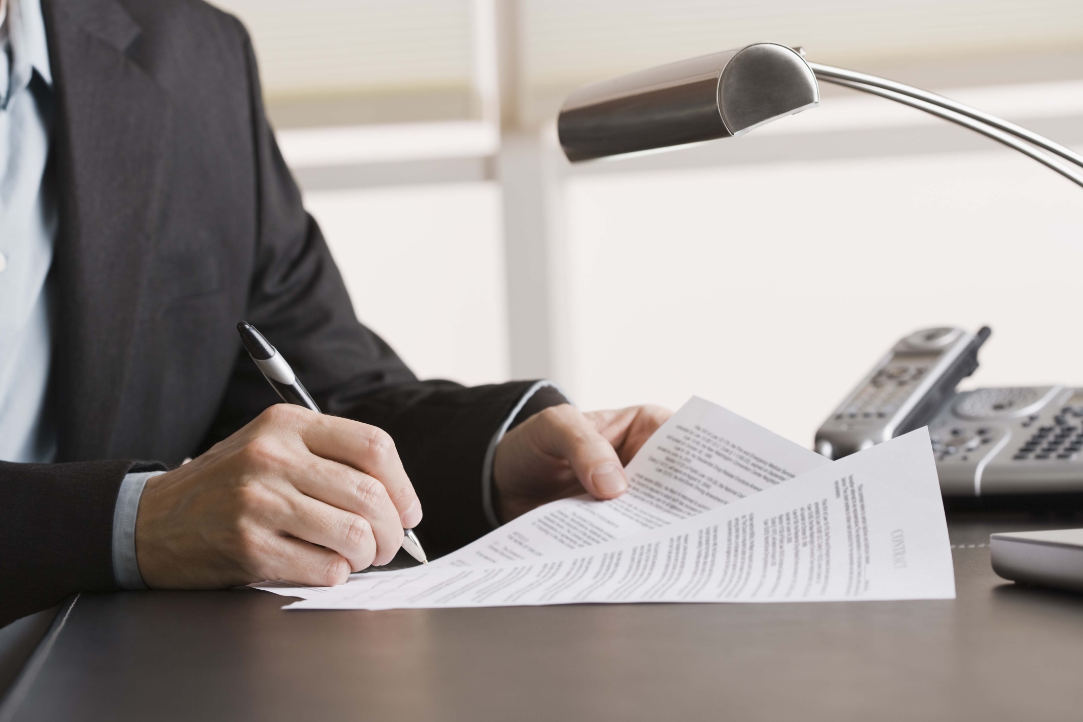 Person writing on paper documents